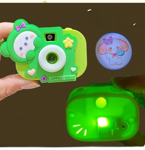 Detailed view of green cartoon bear camera toy with glowing light projection effect