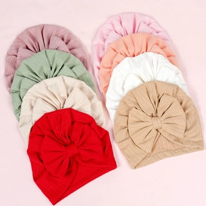 Detailed overhead view of ribbed knit baby turbans with large bows in eight soft colors