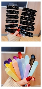 Detailed view of assorted colorful and black plastic hair clips for styling and makeup