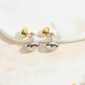 Close-up of dual-tone bean drop earrings in polished gold and silver finish