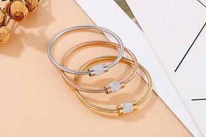 Gros plan de trois bracelets chaîne serpent en or, or rose et argent avec zircons incrustés