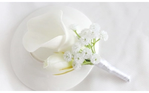 Detail of white calla lily wedding boutonniere with satin ribbon and baby's breath