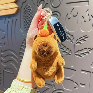 Cute Capybara plush keychain with orange on head held by hand for bag accessory