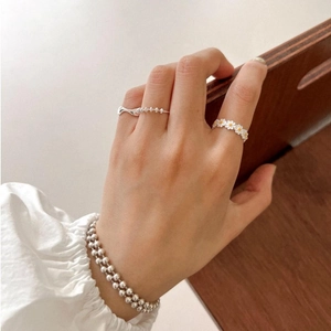 Elegant 925 sterling silver daisy ring and beaded bracelet set worn on a finger