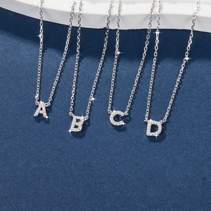 Close-up of silver 925 sterling silver necklaces with sparkling diamond-set A B C D letter pendants
