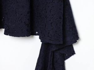 Close-up of intricate navy blue crochet lace texture and pattern on midi dress fabric
