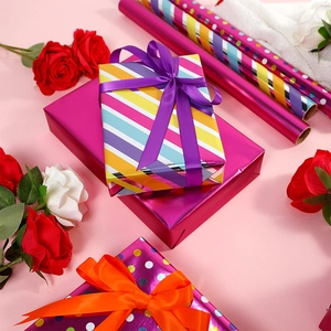Colorful striped and polka dot gift wrapping paper rolls with silk ribbons for birthdays