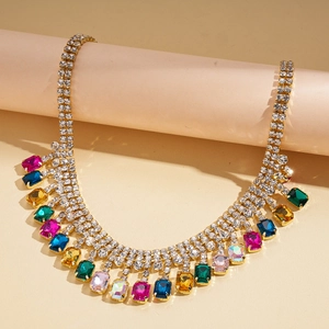 Close-up of geometric square pendant with colorful rhinestones and gold tassel detail