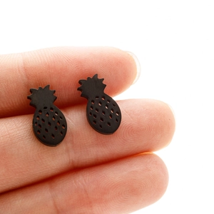 Close-up of minimalist matte black pineapple stud earrings held to show tiny size