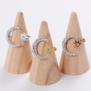 Detailed close-up of crescent moon and star rings in gold, silver and rose gold finishes