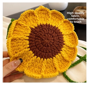 Detail of handmade crochet sunflower bag featuring yellow petals and green shoulder strap