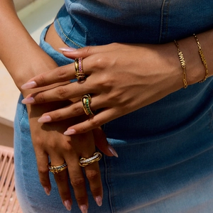 Macro shot of gold zircon rings and MAMA letter bracelet set worn on hand