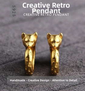 Detailed macro of gold-plated S925 silver cat earrings with a matte vintage finish