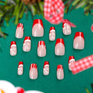 French style Christmas press-on nails with red tips and festive Santa hat patterns