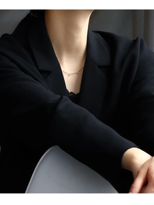 Close-up of minimalist gold plated necklace with three round zircon pendants on a model