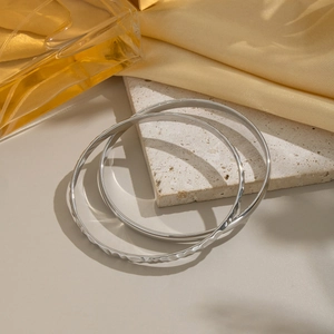 Dettaglio di bracciali in acciaio inossidabile argento martellato e liscio su base