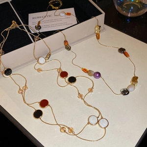 Détail d'un collier de perles vintage avec pierres en résine sur carte élégante