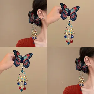 Détail de pince à cheveux papillon brodée avec glands en perles colorées et pendentif goutte