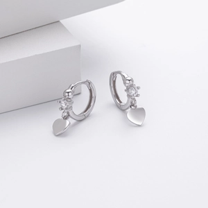 Detail of s925 silver hoop earrings featuring a heart pendant and sparkling zircon