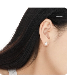 Detail view of a brushed matte S925 sterling silver teardrop stud earring on a model