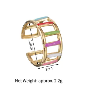 Detail shot of golden striped open ring featuring vibrant multi-colored enamel layers