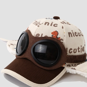 Detail of corduroy kids pilot hat with goggles and cute dinosaur print design