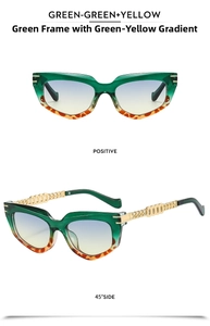 Detail view of cat eye sunglasses with green gradient lenses and gold chain temples