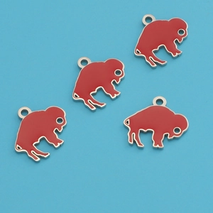 Detail of four red enamel buffalo pendants on blue background with silver metal edges