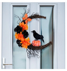 Détail d'une couronne de lune d'Halloween avec corbeau, citrouille et fleurs orange