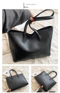 Detail view of black tote bag showing smooth leather texture and vertical stitching accents