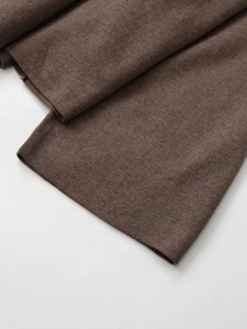 Close-up of high-density brown knitted fabric texture and fine edge stitching detail