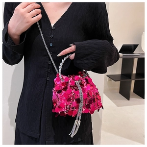 Hot pink sequin bucket bag featuring silver chain strap and fringe tassels on a model