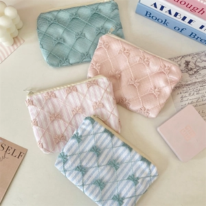 Detail of four quilted fabric coin purses with bows in various colors and patterns