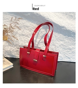 Detail of red glossy shoulder bag with sleek metallic buckle and minimalist design