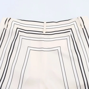 Nahaufnahme geometrischer schwarzer Linien auf weißer Twill-Hose mit Gürtelschlaufen