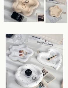 Detail of heart and flower shaped ceramic jewelry display trays in beige and speckled white