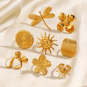 Golden stainless steel ring set featuring dragonfly, flower, and geometric sun designs
