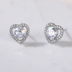 Macro shot of silver plated heart stud earrings with sparkling round zircon setting