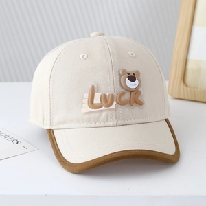 Détail de la casquette bicolore pour enfant avec écusson ours Luck et coutures précises