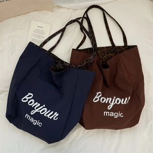Flat lay of navy and brown tote bags with leopard print straps and Bonjour Magic text