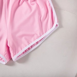 Detail of pink sports shorts with white piping, showing high-elasticity knitted fabric texture