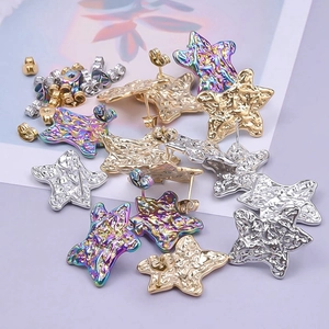 Macro detail of star-shaped earrings with hammered metal texture in gold and silver