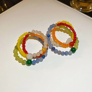 Macro shot of colorful natural stone beaded earrings on white leather background