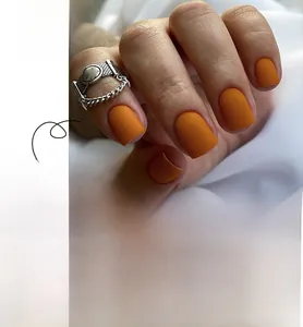 Macro detail of matte orange press-on nails showing square shape and texture