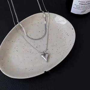 Double-layered silver heart pendant necklace featuring flat and thin snake chains