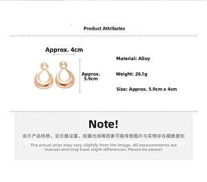 Detail view of large hollow water drop earrings in golden alloy with high metal luster