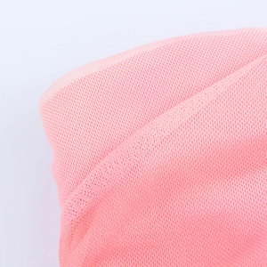 Vue macro détaillée de la texture du tissu en maille rose sur la robe froncée