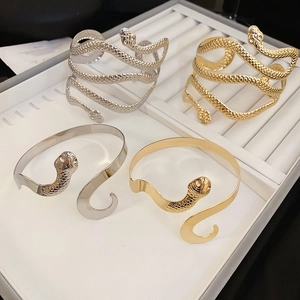 Détails de divers bracelets serpents ouverts en finitions texturées et polies or ou argent