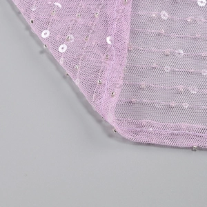 Détail du tissu en maille violette avec des paillettes argentées sur une robe de soirée