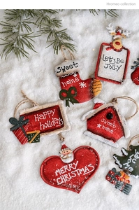 Vintage metal Christmas pendants with holiday greetings on snowy pine branch background